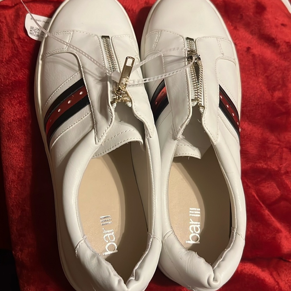 White sneakers with black and red metallic stripe